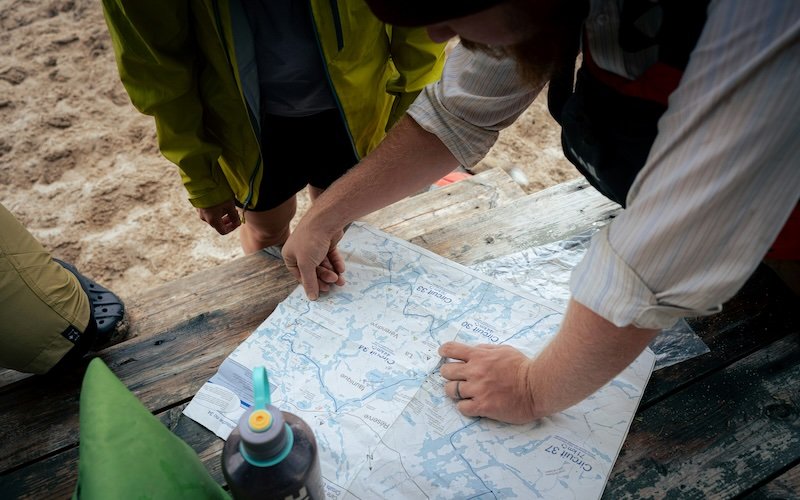 Group of backpackers planning their trip around a campsite